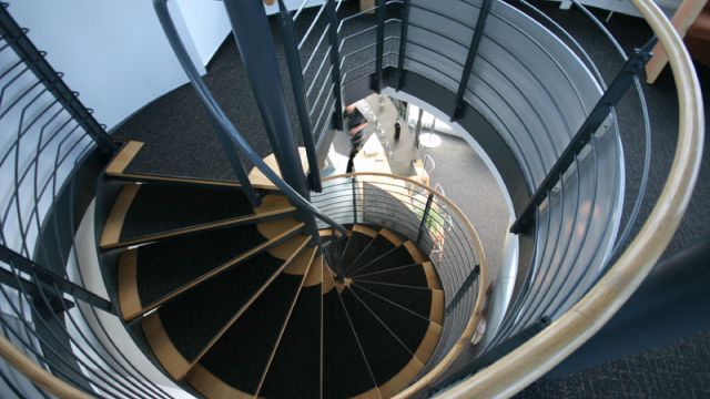 Eine große Wendeltreppe in einer modernen Wohnung in Magdeburg lädt zur Erkundung der oberen Etage ein.