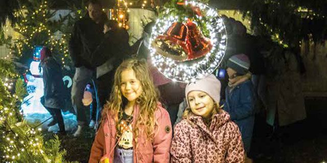 Kinder genießen die festliche Winterbeleuchtung, während eine gemütliche Wohnung in Magdeburg zum Mieten einlädt.